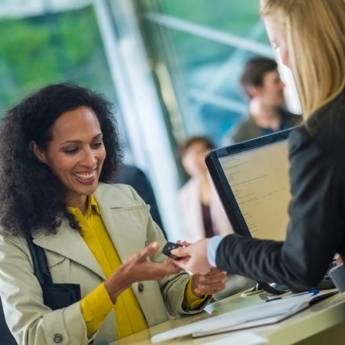 Woman receiving a key from a woman in a suit.